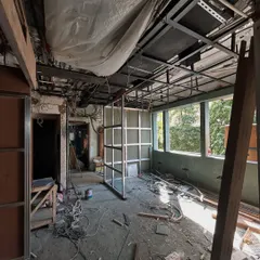 The raw beginnings of a transformation. A construction site reveals the bones of the building, with exposed framing and wiring, ready for its new form.
