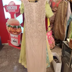 A full-length view of a heavily sequined gown in a soft beige hue with contrasting lime green sleeves. This unique sample piece showcases the kind of designer finds available during our clearance sales.