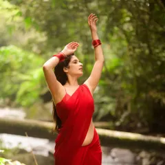 This shot captures a sense of movement and dance. The flowing red saree against the backdrop of the water is pure poetry.
