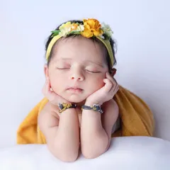 Another beautiful example of the 'chin on hands' or 'froggy' pose, with a lovely floral headband adding a touch of sunshine.