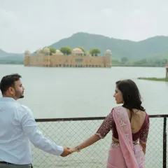 A "follow me" style shot with the beautiful Jal Mahal in the background. This pose creates a sense of journey and togetherness, perfect for a pre-wedding story.