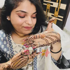 A happy client showing off her simple and elegant mehndi design, perfect for any party or small occasion.