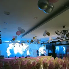 A wide shot of the baby shower venue, showing how I use floating balloon bunches and stage decor to fill the entire space.