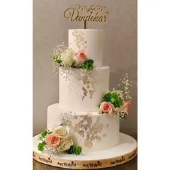 For a truly grand celebration, I created this three-tier eggless chocolate roasted hazelnut wedding cake. It combines rich flavor with the elegance of fresh flowers and delicate 24K gold leaf accents, making it a memorable centerpiece.