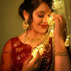 A close-up of the model with the fairy lights, creating a beautiful bokeh effect and a warm, celebratory mood.