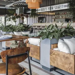 We created comfortable lounge seating pockets for a more intimate experience. These areas, furnished with plush cushions and surrounded by greenery, invite guests to relax and enjoy the space at their leisure.