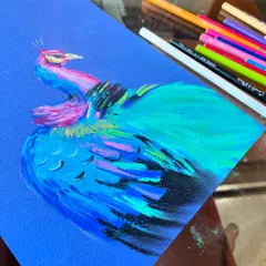 As I build the layers, the peacock's form begins to take shape. I use different shades of blue and green pastels to create the texture of the feathers.