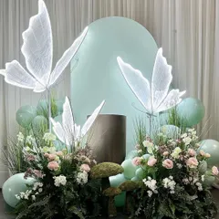 A beautiful photo corner from the enchanted forest theme. The glowing butterflies seem to float above lush floral arrangements, creating a magical backdrop for pictures.