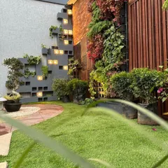 This image from my experience center showcases a creative wall design. It combines a vertical garden with an integrated shelving structure made of concrete blocks, which are backlit for a dramatic effect at night.