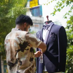 A behind-the-scenes shot of me adding the final touches to a navy blue tuxedo. Every detail, from the button to the pocket square, is personally checked for perfection.