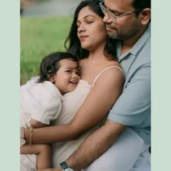 A warm family embrace. The little one is held securely between his parents, a perfect picture of love, comfort, and family connection.