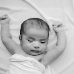 A sleepy stretch captured in timeless black and white. This focuses on the baby's form and delicate features.
