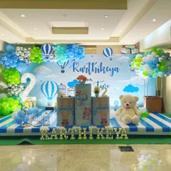 A whimsical hot air balloon theme for a second birthday. I used a sky-blue backdrop, cloud-like balloons, and themed pedestals to create a feeling of floating in the air.