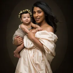 A mother and her baby captured in a beautiful fine art style. The soft, directional light creates a classic, painting-like quality.