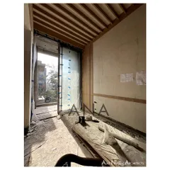 A view of the wood-paneled ceiling and wall details being installed at the DLF Phase 1 residence. This shows the early stages of layering materials to create a contemporary aesthetic.