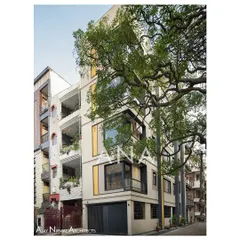 The Yellow Line Apartment building situated within its neighborhood context. The design stands out for its modern aesthetic while respecting the scale of the adjacent properties, using a tree to frame its verticality.
