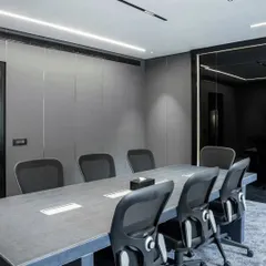 For this chairman's conference room, I focused on creating a space with a strong, masculine aesthetic. I used textured leather panels on the walls and a custom-made conference table with a croc-style leather finish, complemented by a full-wall black lacquer glass writing board for a modern, sophisticated look.