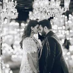 A black and white shot that captures the pure romance of the moment. The incredible detail of the sangeet lehenga and the chandelier-filled backdrop create a timeless, magical feel.