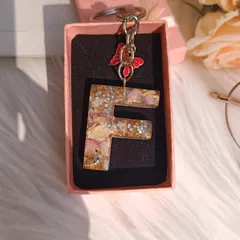 Another beautiful alphabet keychain, this time the letter 'F'. It's filled with preserved petals and glitter, and comes with a delicate butterfly charm.