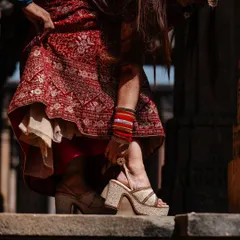 A detail shot of the bride's traditional bangles and modern footwear, taken at a stunning heritage stepwell in Gujarat.