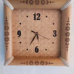 This unique wall clock is framed with natural bamboo and features a woven bamboo face. The intricate pyrography designs on the frame add an artistic, handcrafted touch, making it a functional piece of wall art.