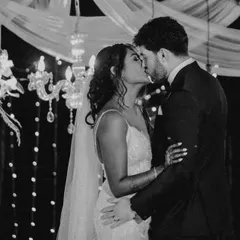 A timeless black and white photograph of the couple's first kiss, framed by elegant decor and soft lighting. This classic style emphasizes emotion and creates a truly romantic memory.