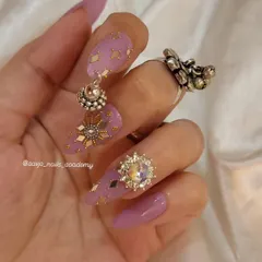 Another angle of the purple and gold Navratri nails, showing off the large crystal charm and the delicate placement of the gold accents.