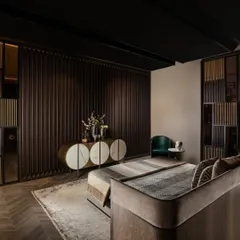 In this bedroom, a lacquered wall paneling with vertical grooves provides a textured backdrop for our custom console. The console itself is a statement piece, constructed with semi-circular marble tiles and metal accents.