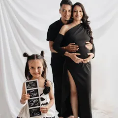 A creative and heartwarming way to announce a new arrival. This studio maternity portrait includes the excited big sister-to-be proudly holding the sonogram pictures, turning the session into a full family celebration.