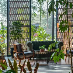 A patterned terracotta screen provides privacy and filters sunlight, casting intricate shadows across the room. This element of biophilic and culturally-inspired design adds texture and artistry while connecting the interior to the outdoors.