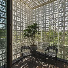 For this balcony, I created a complete enclosure using custom-patterned metal screens. This provides privacy and shade while creating a stunning play of light and shadow, making the space feel like a private, open-air room.