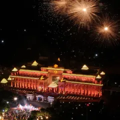 An aerial still of fireworks erupting over a brightly lit palace during a wedding sangeet night. This drone shot captures the festive atmosphere and the architectural beauty of the venue, providing a perspective that ground cameras simply cannot achieve.