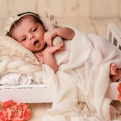 A sweet, expressive face from a baby lying in a tiny bed prop. It's wonderful to capture their personality as they look around and take in their new world.