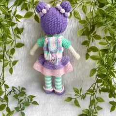 A beautiful doll with purple hair buns and a tutu dress. She also comes with a tiny backpack for her adventures. The striped stockings are attached, but her dress and shoes are removable.