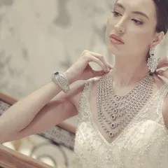 An elegant shot from a jewelry modeling photoshoot. The model is adorned with a stunning multi-layered diamond necklace, captured with soft, flattering light.