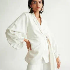An all-white pantsuit with voluminous sleeves and a tie-waist detail. For this shoot, I aimed for a look that was sharp and architectural, showcasing modern tailoring and a clean, minimalist aesthetic.