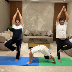 A fun and challenging moment from a corporate session, with participants trying Vrikshasana and Chakrasana. Yoga at work can boost team morale and physical health.