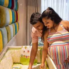 A beautiful lifestyle shot of a couple in their baby's nursery, looking at the crib together. This is a wonderful way to capture the anticipation in your own space.