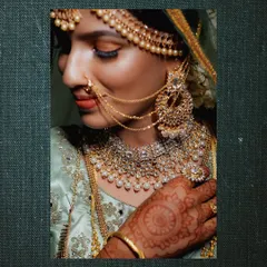 A close-up portrait highlighting the bride's exquisite taste in jewelry, from her maang tikka to her elaborate nose ring and necklace.