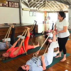 A typical scene from my class, where students use belts for Supta Padangusthasana. The belt allows for a deeper hamstring stretch while keeping the spine and pelvis stable on the floor.