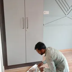 A fresh coat of light grey paint being applied to a two-door wardrobe. This solid colour painting service can completely transform the look and feel of a room.
