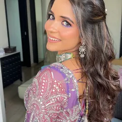 A half-up style with a simple braid and soft waves, a versatile look for a Mehendi or Haldi.