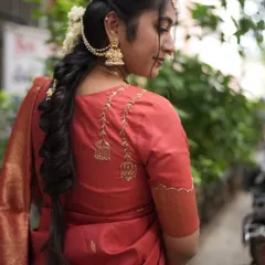 A closer look at the back of my red festive saree blouse. The delicate embroidery features a beautiful hanging design, adding a unique touch to a traditional boat neck blouse. It's all in the details.
