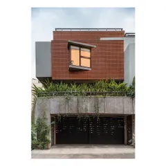 The street-facing elevation of the Nairy Residence is designed for privacy at the ground level, with a perforated metal gate and a solid concrete plinth. Above, a projecting bay window with an angled sill creates a dynamic architectural feature while capturing specific views.