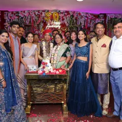 The entire family gathers around the couple for a group photo during their golden wedding anniversary celebration.