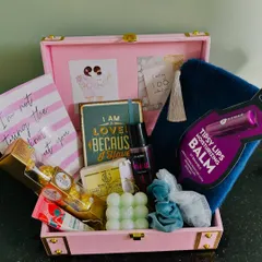 A look inside one of our bridesmaid proposal hampers. This pink trunk is filled with goodies like Ferrero Rocher, a bubble candle, a cozy pouch, skincare, and a sweet note to pop the question.