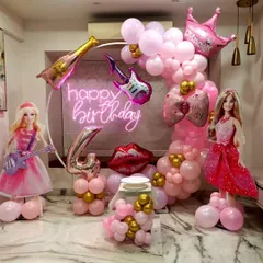 A glamorous Barbie-themed birthday party perfect for a little rockstar, featuring pink and gold balloon decor, Barbie doll cutouts, and a "Happy Birthday" neon sign.