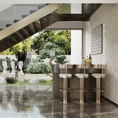 Detail is paramount in our luxury interiors. This close-up shows a custom-designed bar console with a gold-fluted metal finish, paired with elegant high stools. Positioned beneath a staircase, it offers a beautiful view of the garden, making it a perfect spot for entertaining.