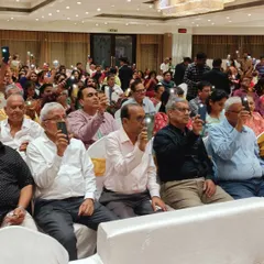 The audience participating in a flashlight moment during a 70th birthday bash. The event featured an unplugged band, fun games, a DJ, and an LED screen for a truly grand celebration.