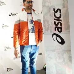 Posing at the ASICS media wall before the event. As a host for brand launches, I ensure I am aligned with the brand's image and ready to represent them on stage.